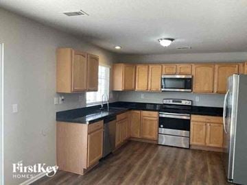 Denver house for rent - a kitchen with wooden cabinets and stainless steel appliances