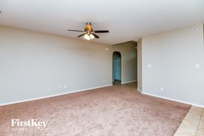 Fort Worth house for rent - A room with a ceiling fan and a doorway leading to another room.