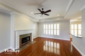 Trussville house for rent - A spacious room with a fireplace and wooden floors.