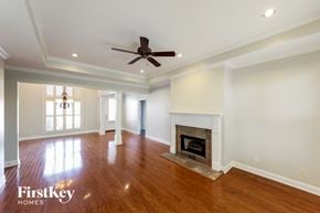 Trussville house for rent - A spacious living room with a fireplace and a ceiling fan.