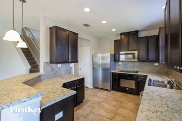 San Antonio house for rent - a kitchen with granite counter tops and a stainless steel refrigerator