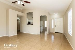 Glendale house for rent - an empty living room and kitchen with a ceiling fan