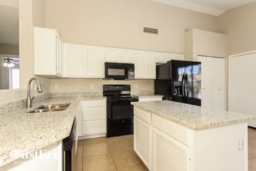 Glendale house for rent - a kitchen with granite counter tops and black appliances
