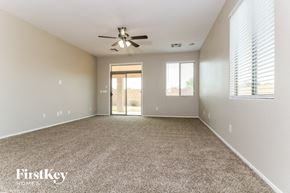 Laveen house for rent - an empty living room with a ceiling fan and window