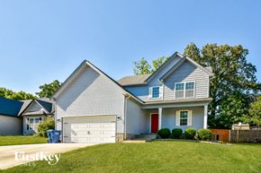 Clarksville house for rent - a blue house with a white garage door and a green lawn