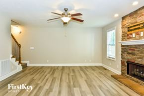 Clarksville house for rent - a living room with a fireplace and a ceiling fan