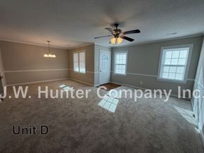 Wilson apartment for rent - A spacious room with a ceiling fan and carpeted floor.