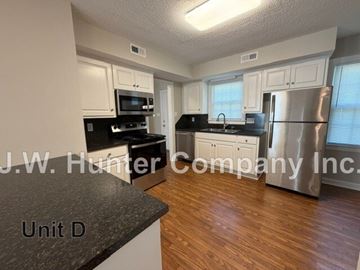 Wilson apartment for rent - A kitchen with white cabinets and a black countertop.
