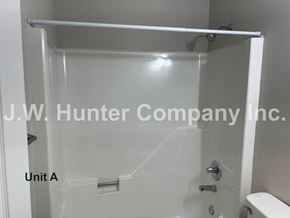 Wilson apartment for rent - A shower stall with a white tub and a white toilet.