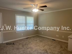 Wilson apartment for rent - A room with a carpet floor and a ceiling fan.