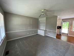 Wilson apartment for rent - A spacious room with a ceiling fan and a window with blinds.