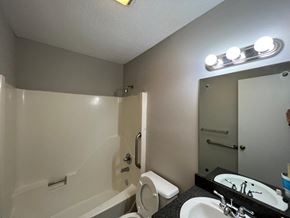 Wilson apartment for rent - A bathroom with a white tub, sink, and toilet.