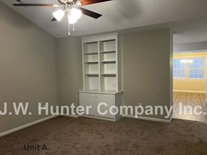 Wilson apartment for rent - A room with a ceiling fan and a shelf unit.