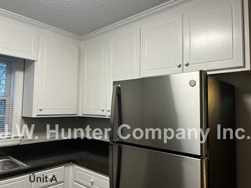 Wilson apartment for rent - A stainless steel refrigerator in a kitchen with white cabinets.