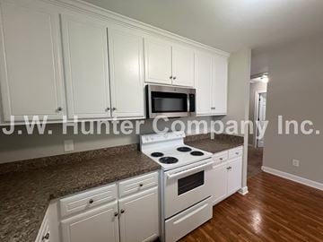 Wilson apartment for rent - A kitchen with white cabinets and a granite countertop.