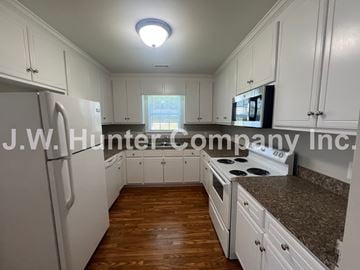 Wilson apartment for rent - A kitchen with white cabinets and a refrigerator.