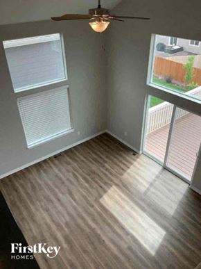 Colorado Springs house for rent - A room with a ceiling fan and a view of a backyard.