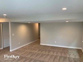 Colorado Springs house for rent - A room with a carpeted floor and a door on the left side.