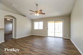 Phoenix house for rent - an empty living room with wood floors and a ceiling fan