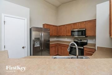 Phoenix house for rent - a kitchen with stainless steel appliances and wooden cabinets