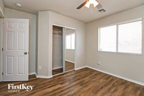 Phoenix house for rent - a bedroom with a door to a closet and a window