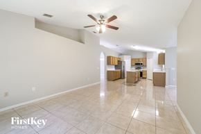 Poinciana house for rent - A spacious room with a ceiling fan and tiled flooring.