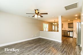 Concord house for rent - A spacious room with a ceiling fan and wooden flooring.