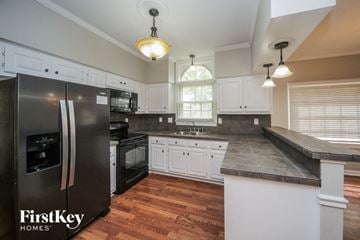 Collierville house for rent - a kitchen with white cabinets and a stainless steel refrigerator