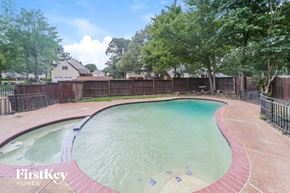 Collierville house for rent - a swimming pool with a fence around it and trees