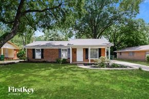 Charlotte house for rent - a small brick house with a lawn and trees