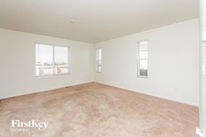 Colorado Springs house for rent - A room with a carpeted floor and two windows.