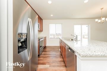 Colorado Springs house for rent - A modern kitchen with a stainless steel refrigerator and wooden floors.