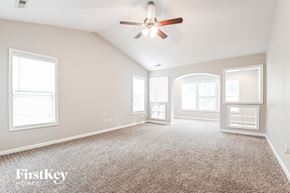 Fuquay Varina house for rent - A spacious room with a carpeted floor and a ceiling fan.