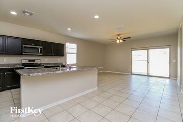 Florence house for rent - A kitchen with black cabinets and a granite countertop.
