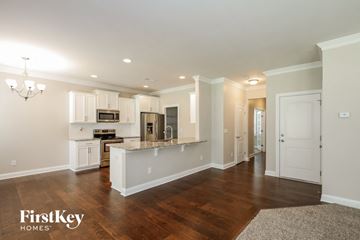 Charlotte house for rent - an open kitchen and living room with white cabinets and a counter top