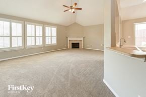 Humble house for rent - an empty living room with a ceiling fan and a fireplace