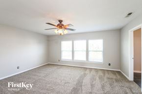 Noblesville house for rent - a bedroom with a ceiling fan and a large window