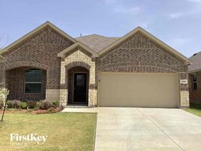 Forney house for rent - front view of a brick house with a garage door