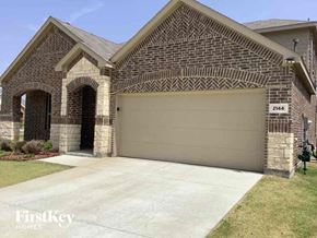 Forney house for rent - a garage door on a brick house with a concrete driveway