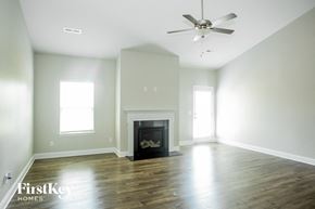 Locust house for rent - an empty living room with a fireplace and a ceiling fan