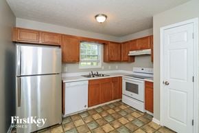 Temple house for rent - a kitchen with white appliances and wooden cabinets