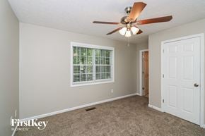 Temple house for rent - a bedroom with a ceiling fan and a white door