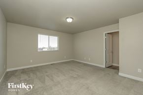 Colorado Springs house for rent - A room with a carpeted floor and a door on the right side.