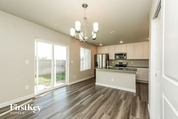 Colorado Springs house for rent - A well-lit kitchen and living room with wooden floors and white walls.