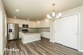 Colorado Springs house for rent - A kitchen with wooden floors and white cabinets.