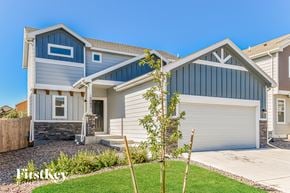 Colorado Springs house for rent - A house with a garage and a tree in front.