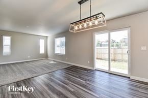 Colorado Springs house for rent - A spacious room with wooden floors and a large window.