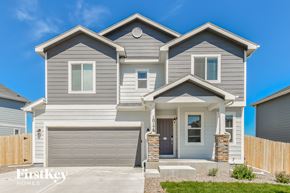 Colorado Springs house for rent - A modern house with a grey and white exterior and a stone pillar at the entrance.