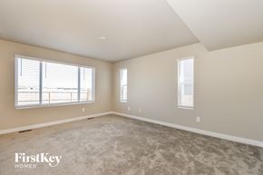 Colorado Springs house for rent - A spacious room with a carpeted floor and two windows.