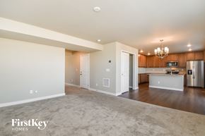 Colorado Springs house for rent - A spacious, empty living room with a kitchen in the background.